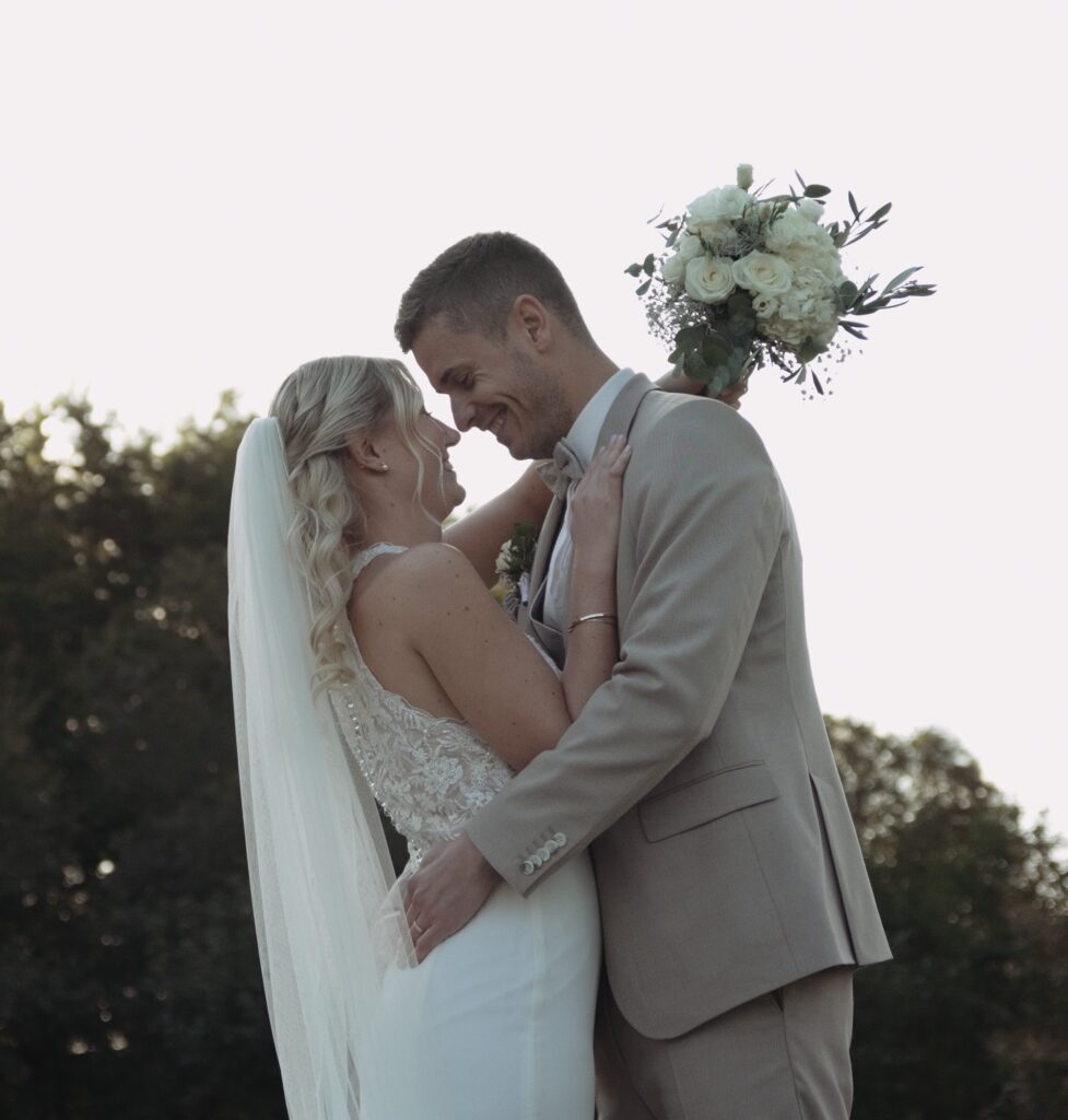 Madeleine und Dennis umarmen sich liebevoll an ihrem Hochzeitstag