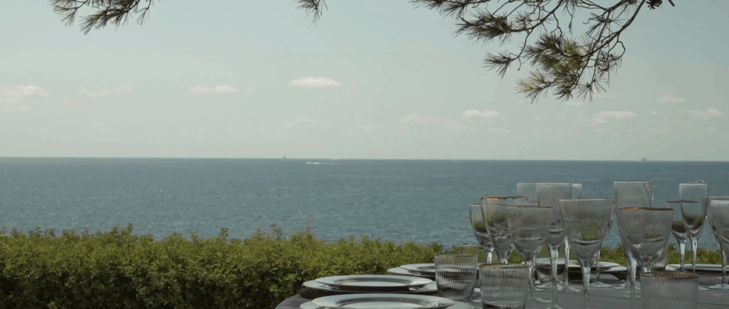 Blick über festlich gedeckte Tische auf das glitzernde Meer bei der Hochzeit von Carolina und Daniel Peukmann auf Mallorca